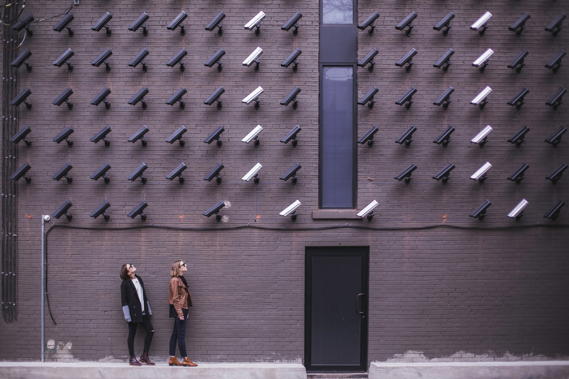 Wall of security cameras looking down on two women