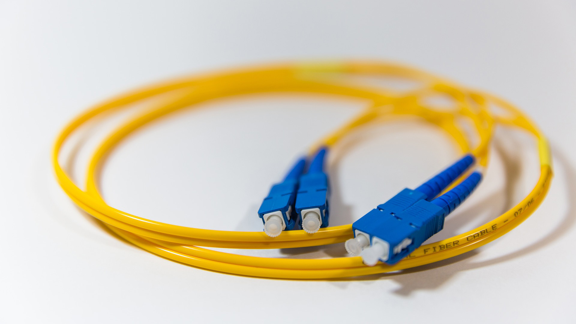 Short yellow rolled up fiber cable with blue connectors